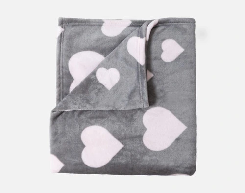 The Blushing Hearts Fleece Throw folded up into a square with a corner folded down.