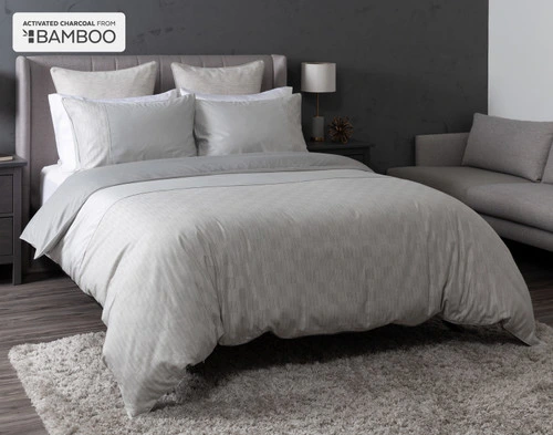 Angled view of our Marco Duvet Cover dressed over a queen bed in a grey bedroom.