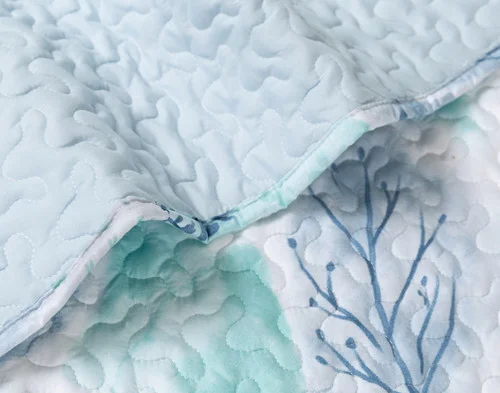 Close-up on the solid backing and botanical surface on our Eliana Coverlet Set.
