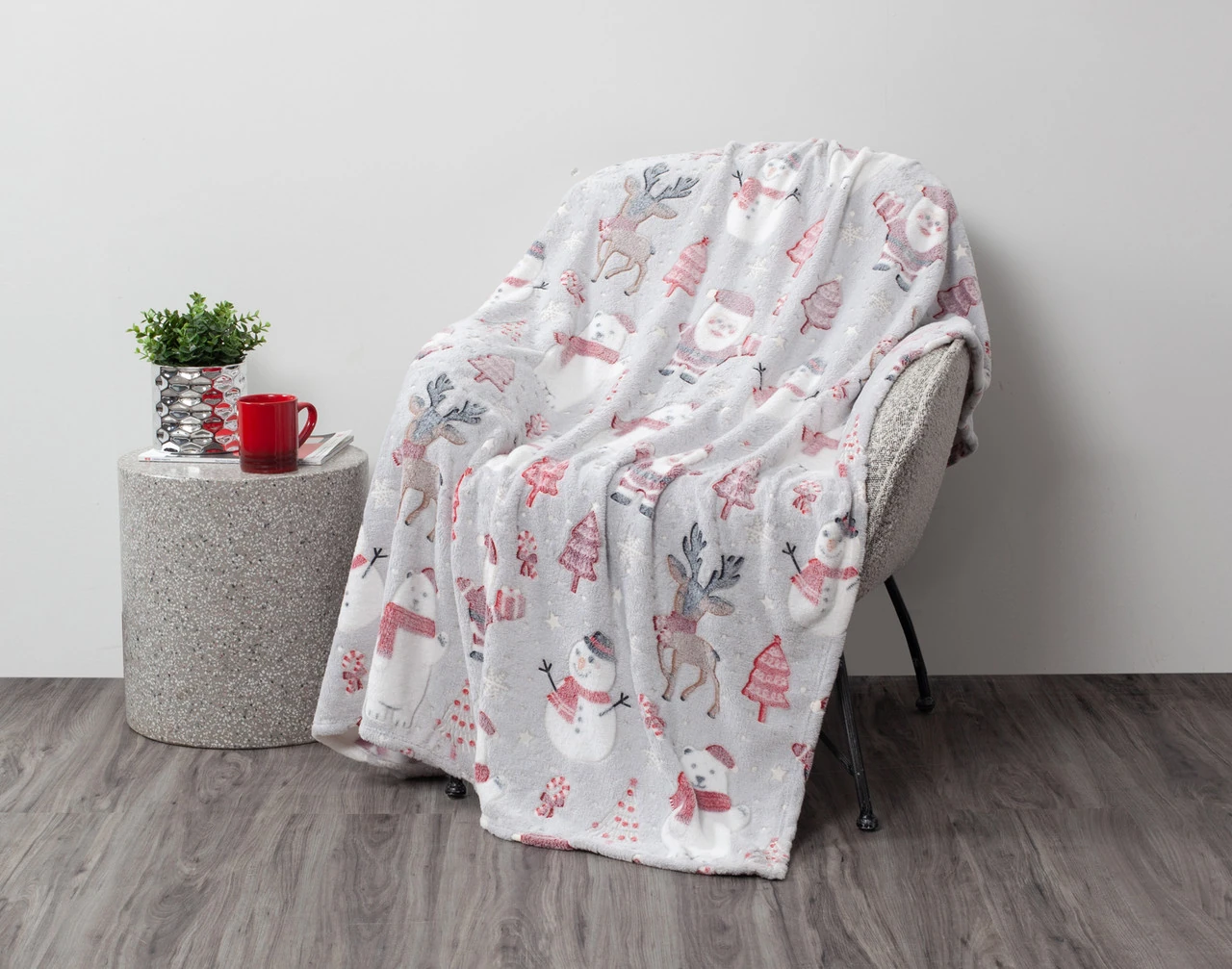 Our North Pole Glow in the Dark Throw draped over a chair in a simple living room.