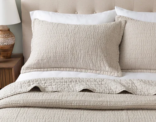 Front view of the pillow shams from our Foothills Quilt Set leaning on a headboard.