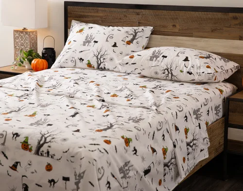 Angled view of an empty queen bed dressed in our Haunted House Cotton Percale Sheet Set.