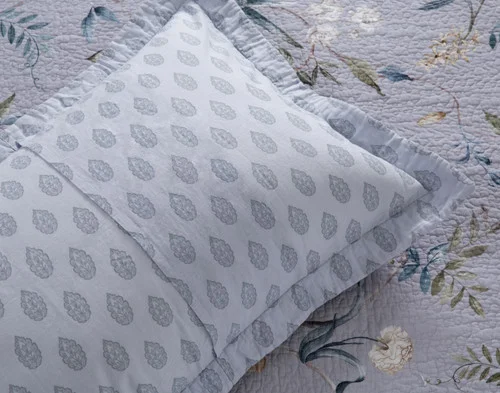 The reverse side of our Sara Cotton Pillow Sham atop our Sara Cotton Quilt.