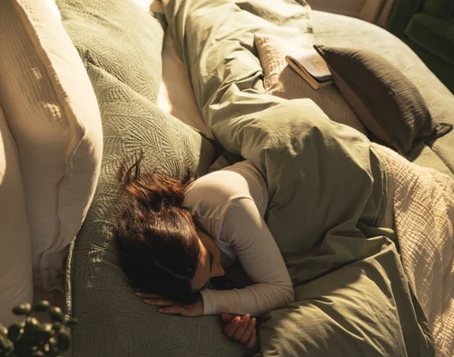 Top-down view of a woman relaxing in a bed dressed in our Matosa collection.