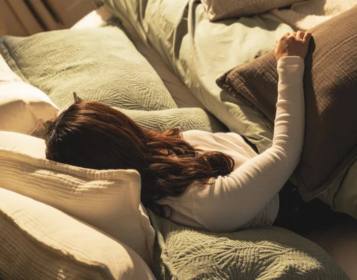 Angled view of a woman relaxing in a bed dressed in our Matosa collection.