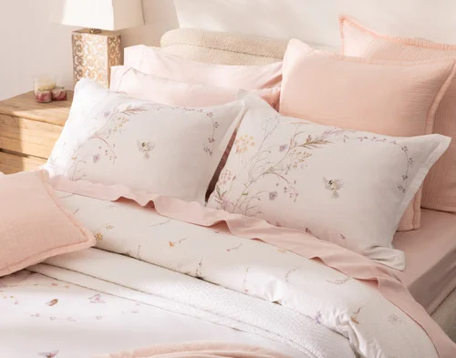 Our Elysium Pillow Shams styled at the head of a bed with pink accessories.