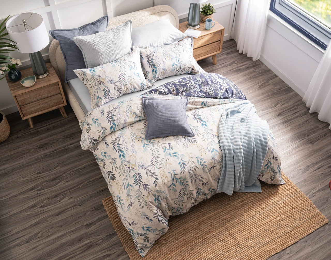Front view of the light pink side of our Kona Bay Duvet Cover dressed with blue accessories.