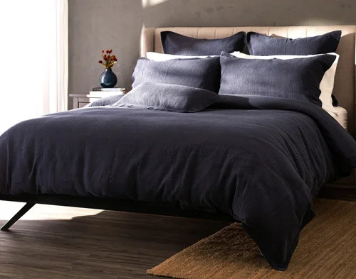 Angled view of our Deep Dive Duvet Cover Set dressed over a plain queen bed.