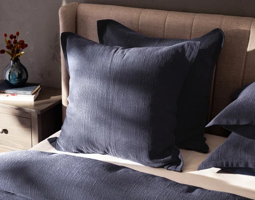 Angled view of our Deep Dive Euro Sham resting on a bed with coordinating duvet cover.