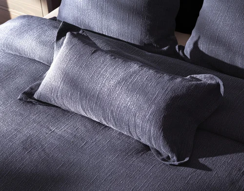 Angled view of our Deep Dive Boudoir Pillow Cover resting on a bed with coordinating duvet cover.