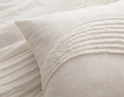 Close up on the corner of our Savary Square Cushion Cover atop our Savary Duvet Cover.