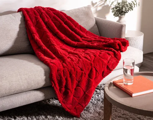 Our Valentine's Fleece Throw - Etched Hearts draped on a grey couch.