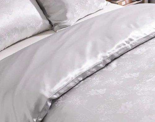 Angled view of our Reflections Silk Blend Duvet Cover Set dressed over a plain bed.