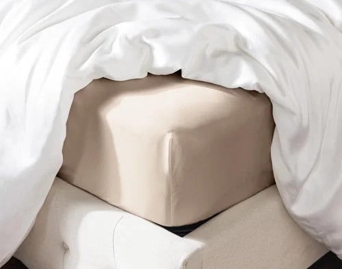 Angled view of our Champagne Silk Blend Fitted Sheet fitted over a mattress.
