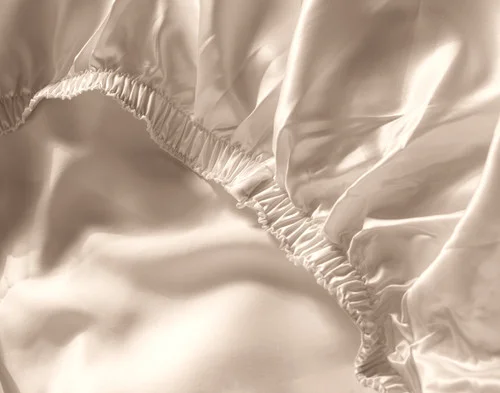 Close-up on the elastic border on our Champagne Silk Blend Fitted Sheet.