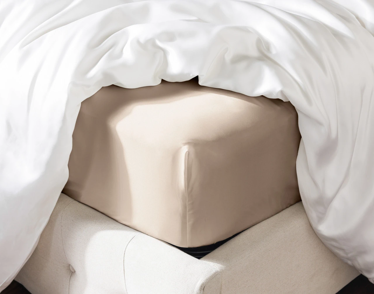 Angled view of our Champagne Silk Blend Fitted Sheet fitted over a mattress.