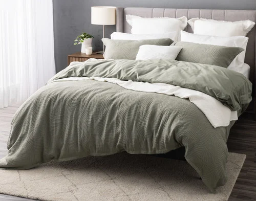 Angled view of our Arden Duvet Cover Set dressing a queen bed with white accessories.
