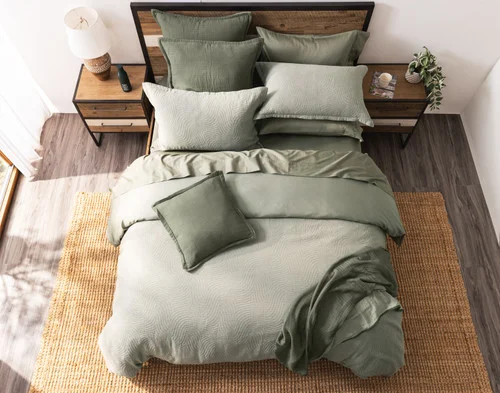 Top-down view of our Arden Duvet Cover Set dressing a queen bed with green accessories.