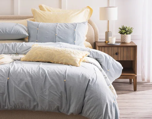 Front, off-centre view of our Clio collection dressing a bed with yellow accessories.