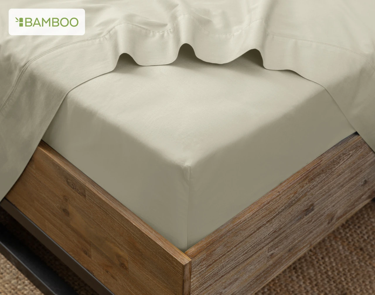 Our Bamboo Cotton Fitted Sheet in Thyme on the corner of a bed with our Bamboo Cotton Flat Sheet in Thistle.