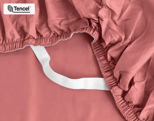 Close-up on the elastic snug fit band on the corner of our Eucalyptus Luxe TENCEL™ Lyocell Fitted Sheet in Raspberry Ice.