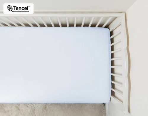 Top view of a crib mattress dressed in our Blue Chalk Eucalyptus Luxe Crib-Sized Fitted Sheet.