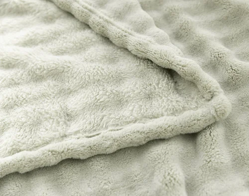 Folded edge of our Sage Bubble Breeze Throw to show its surface and reverse.