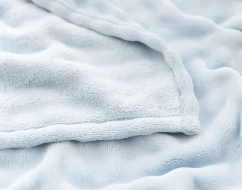 Folded edge of our Powder Blue Bubble Breeze Throw to show its surface and reverse.