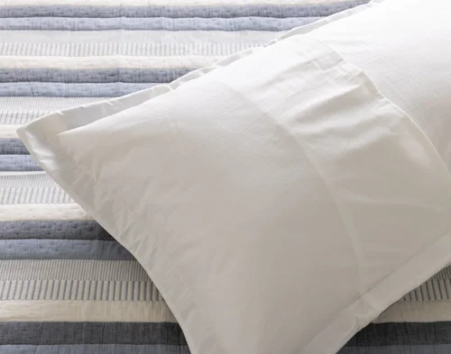 The reverse side of our Piers Cotton Pillow Sham atop our Piers Cotton Quilt.