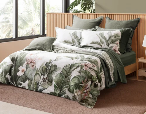 Angled view of our Sail Away collection on a wooden bed in a tropical room.