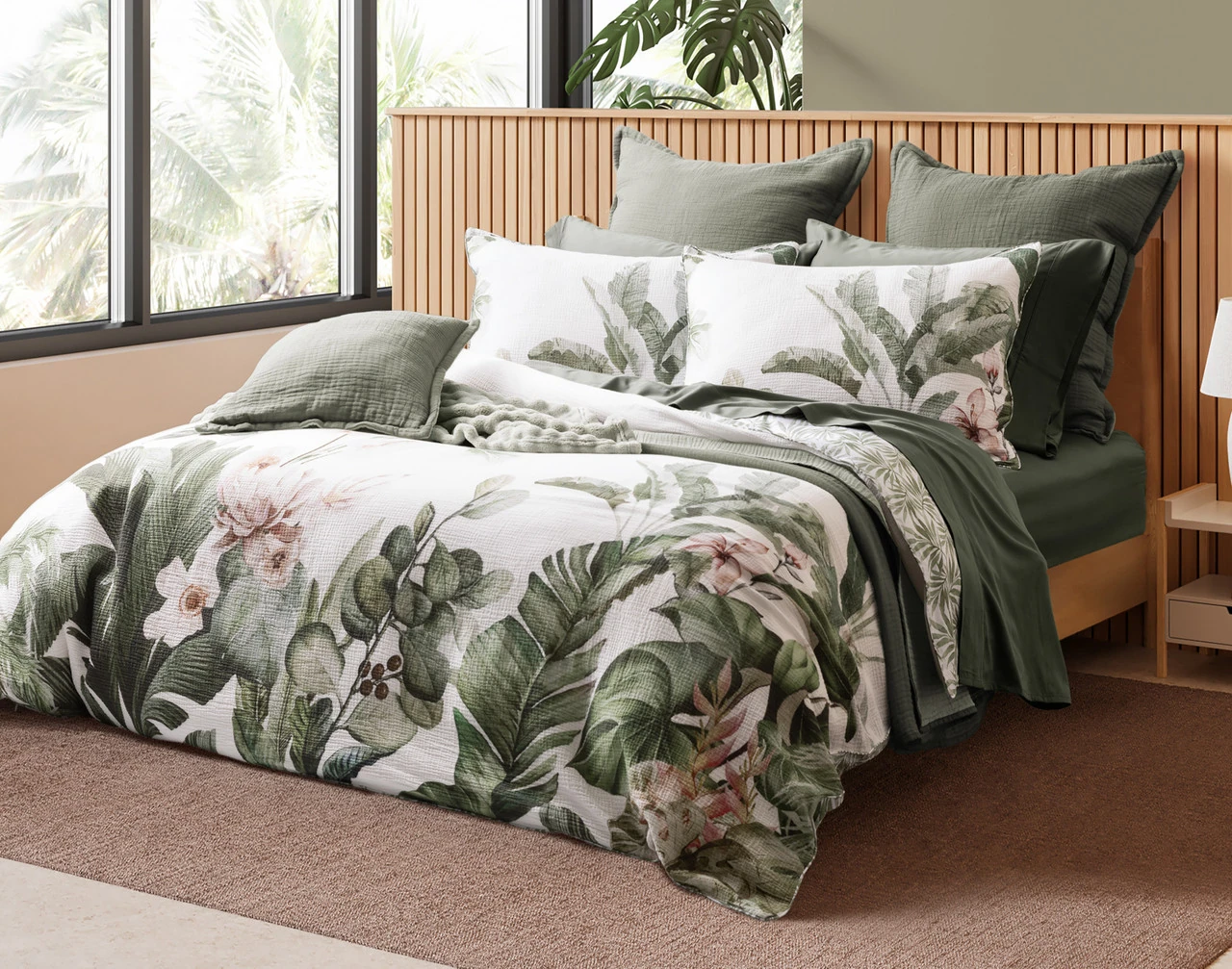 Angled view of our Sail Away collection on a wooden bed in a tropical room.