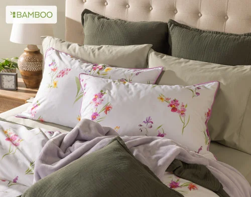 Angled view of our Delicata collection dressing a queen bed with green accessories.