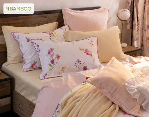 Our Delicata collection dressing the head of a bed with pink and yellow accessories.