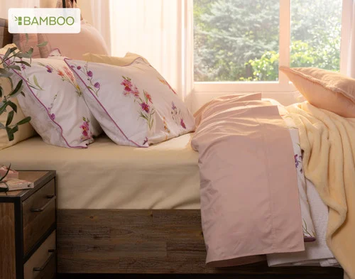 Side view of our Delicata collection dressing the head of a bed with pink and yellow accessories.