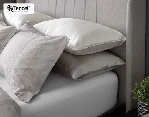 Side view of our Renley Pillow Sham dressing the head of a bed with silk pillowcases.