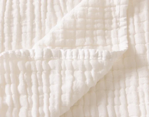 Close up on the folded surface of our Bamboo Gauze Throw in White.