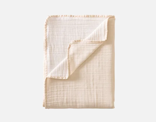 Our Bamboo Gauze Throw in Bone folded into a rectangle.