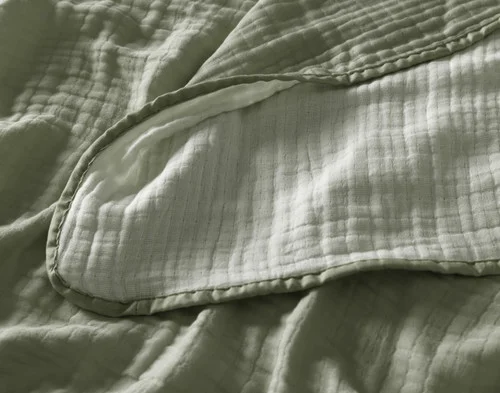 Close up on the textured surface of our Bamboo Gauze Throw in Leaf.
