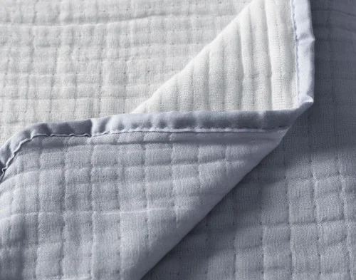 Close up on the folded surface of our Bamboo Gauze Throw in Seaside.