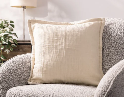Our Bamboo Gauze Square Cushion Cover in Bone on a grey chair.