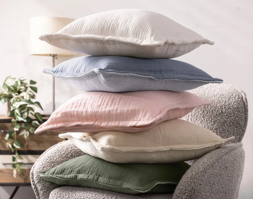 A stack of our Bamboo Gauze Square Cushion Covers on a grey chair.