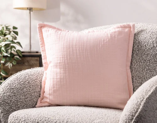 Our Bamboo Gauze Square Cushion Cover in Blossom on a grey chair.