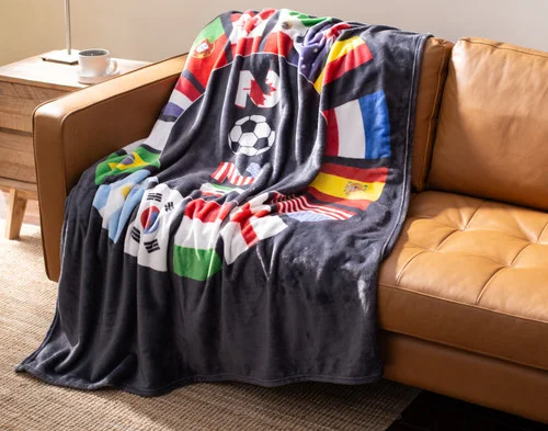 Angled view of our World Cup Fleece Throw draped gently over a couch.