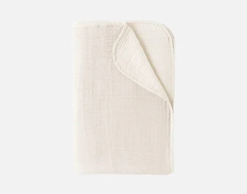 Our White Bamboo Gauze Blanket folded into a neat rectangle over a solid white background.