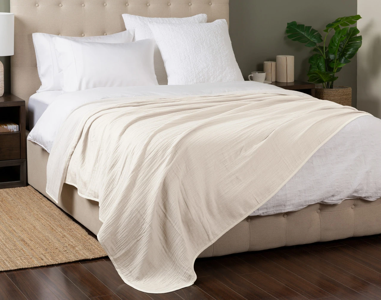 Angled view of our White Bamboo Gauze Blanket spread over a white queen-size bed.