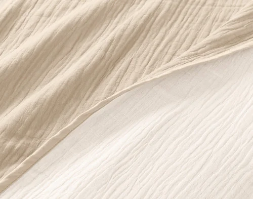 Close-up of our Bone Bamboo Gauze Blanket to show its surface and off-colour reverse side-by-side.