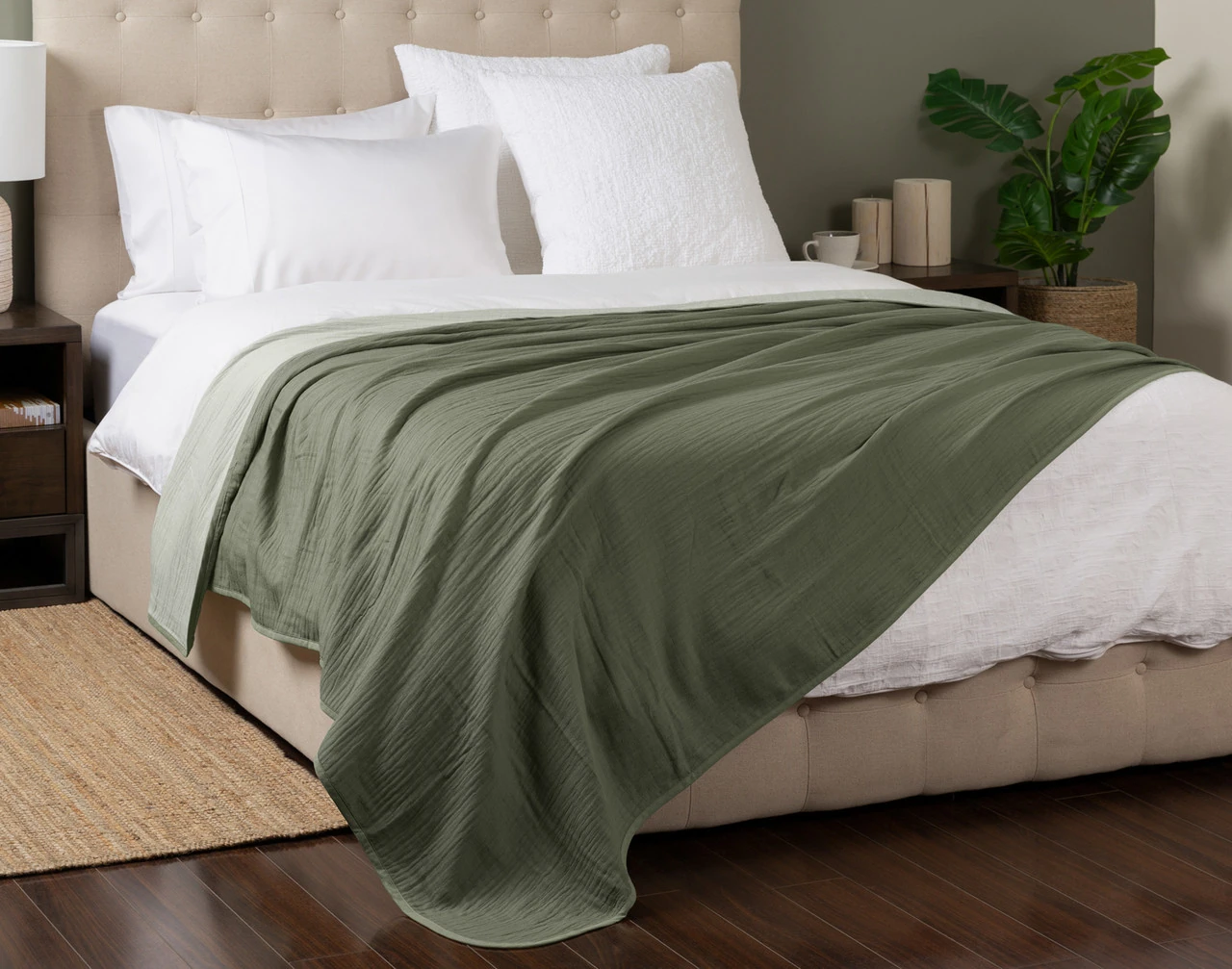 Angled view of our Leaf Bamboo Gauze Blanket spread over a white queen-size bed.