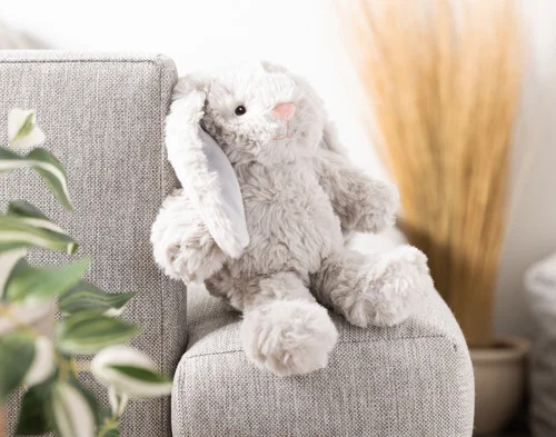 Our Small Easter Plush Bunny Cushion sitting on a couch arm.