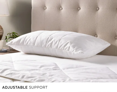 Our PureRest Pillow laying flat over an empty bed.