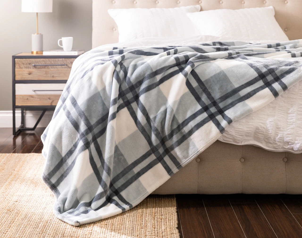 Front view of our Coastline Plaid Blanket draped over a white bed.